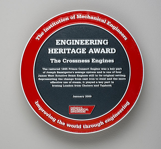Joseph Bazalgette red and black plaque - The Crossness Engines The restored 1865 Prince Consort Engine was a key part of Joseph Bazalgette's sewage system and is one of four James Watt Rotative Beam Engines still in its original setting. Representing the change from cast iron to steel and the more effective use of steam, it played a key part in freeing London from Cholera and Typhoid.
