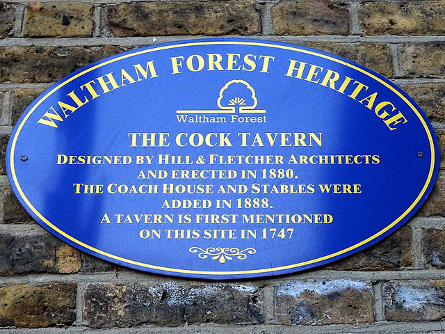Blue plaque № 9668 - The Cock Tavern. Designed by Hill & Fletcher Architects and erected in 1880. The Coach house and stables were added in 1888. A tavern is first mentioned on this site in 1747