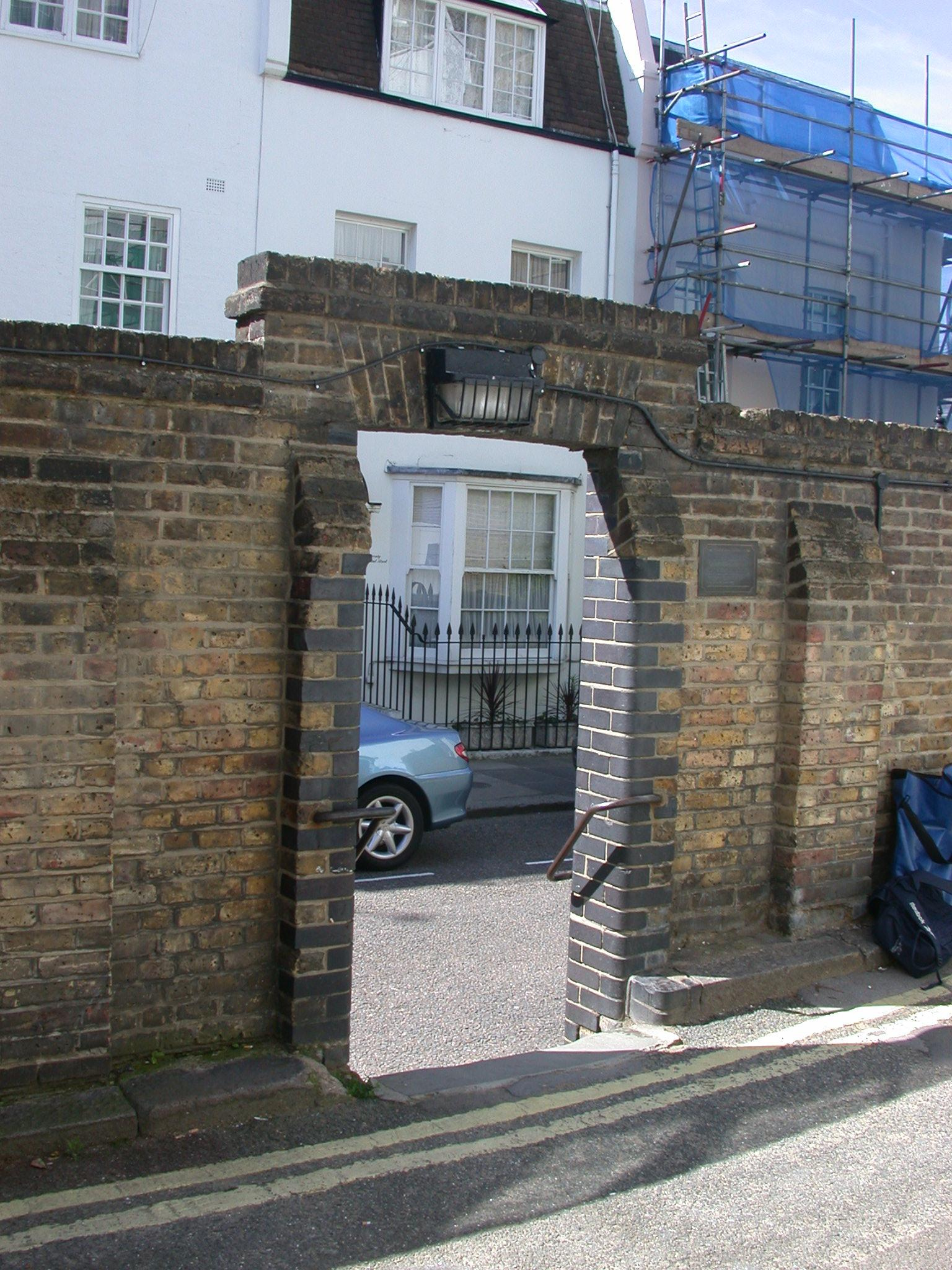 Bronze plaque № 10799 - This boundary wall of the Rutland Estate was destroyed by a bomb during World War II on 25 September 1940.  At the request of residents a right of way was established when the wall was rebuilt by the City of Westminster in 1948 and has become to be known as the 'hole in the wall'  Unveiled on 28 October 1988