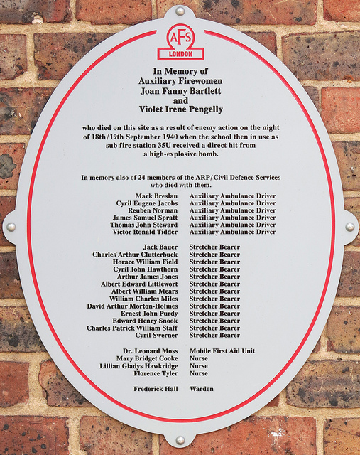 Grey plaque № 11585 - In Memory of Auxiliary Firewomen Joan Fanny Bartlett and Violet Irene Pengelly who died on this site as a result of enemy action on the night of 18th/19th September 1940 when the school then in use as sub fire station 35U (Millwall) received a direct hit from a high explosive bomb. In Memory also of 24 members of the ARP Civil Defence Services who died with them