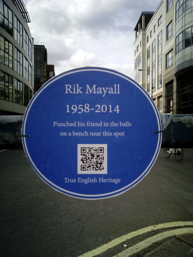 Rik Mayall and Adrian Edmondson blue plaque - Rik Mayall 1958-2014 punched his friend in the balls on a bench near this spot 
