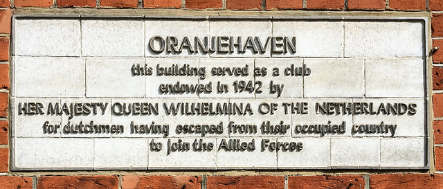 Wilhelmina white plaque - Oranjehaven this building served as a club endowed in 1942 by Her Majesty Queen Wilhelmina of the Netherlands for dutchmen having escaped from their occupied country to join the Allied Forces