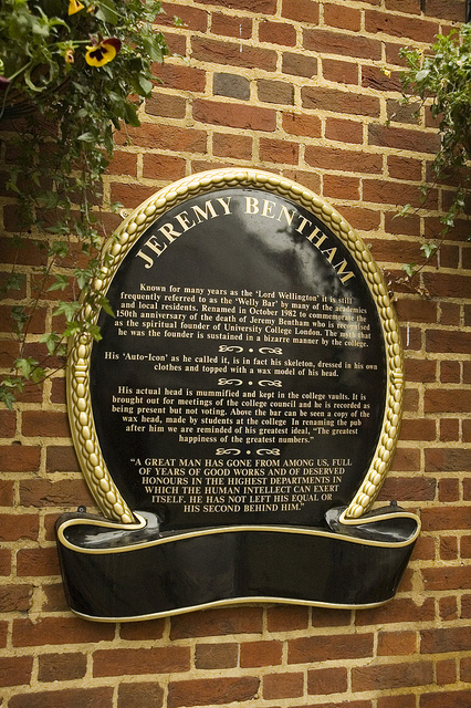 Jeremy Bentham black plaque - JEREMY BENTHAM  Known for many years as the 'Lord Wellington' it is still frequently referred to as the 'Welly Bar' by many of the academics and local residents. Renamed in October 1982 to commemorate the 150th anniversary of the death of Jeremy Bentham who is recognised as the spiritual founder of University College London. The myth that he was the founder is sustained in a bizarre manner by the college.  His 'Auto-Icon' as he called it, is in fact his skeleton, dressed in his own clothes and t