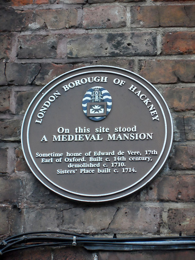Edward de Vere brown plaque - On this site stood a medieval mansion, sometime home of Edward de Vere, 17th Earl of Oxford. Built c. 14th century, demolished c. 1710. Sisters' Place built c. 1714.