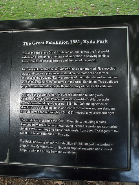 Great Exhibition and Crystal Palace black plaque - The Great Exhibition 1851, Hyde Park    This is the site of the Great Exhibition of 1851. It was the first world exhibition of design, technology and innovation, displaying exhibits from Britain, the British Empire and the rest of the world.    For the first time, the site in Hyde Park has been marked. Five recycled glass and concrete plaques now stand on the footprint and former entrance to the building. Early examples of the materials and techniques used in this project were displayed in the G