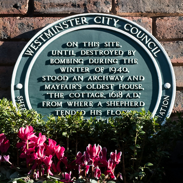 The Cottage, London green plaque - On this site,  until destroyed by  bombing during the  winter of 1940,  stood an archway and  Mayfair's oldest house.  'The Cottage. 1618 A.D.'  from where a shepherd  tended his flock  whilst Tyburn idled nearby.