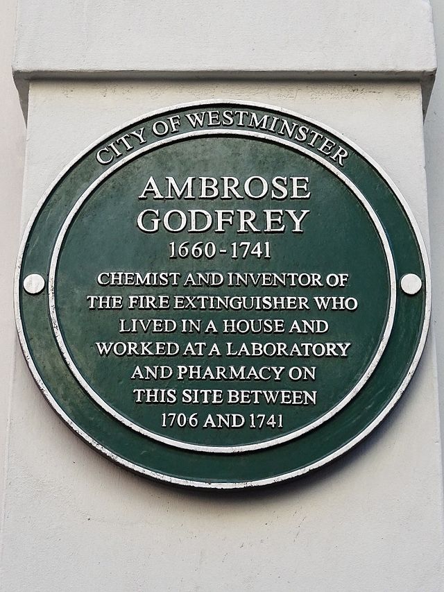 Ambrose Godfrey green plaque - Ambrose Godfrey 1660-1741 Chemist and inventor of the fire extinguisher who lived at a house and worked at a laboratory and pharmacy on this site between 1706 and 1741