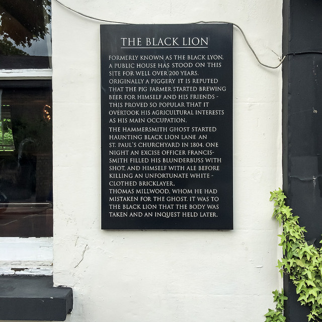 Black Lion, London, Thomas Millwood, and Francis-Smith black plaque - Formerly known as the Black Lyon, a public house has stood on this site for well over 200 years.  Originally a piggery it is reputed that the pig farmer started brewing beer for himself and his friends - this proved so popular that it overtook his agricultural interests as his main occupation.  The Hammersmith Ghost started haunting Black Lion Lane an (sic) St. Paul's churchyard in 1804.  One night an excise officer Francis-Smith filled his blunderbuss with shot, and himself with ale before kill