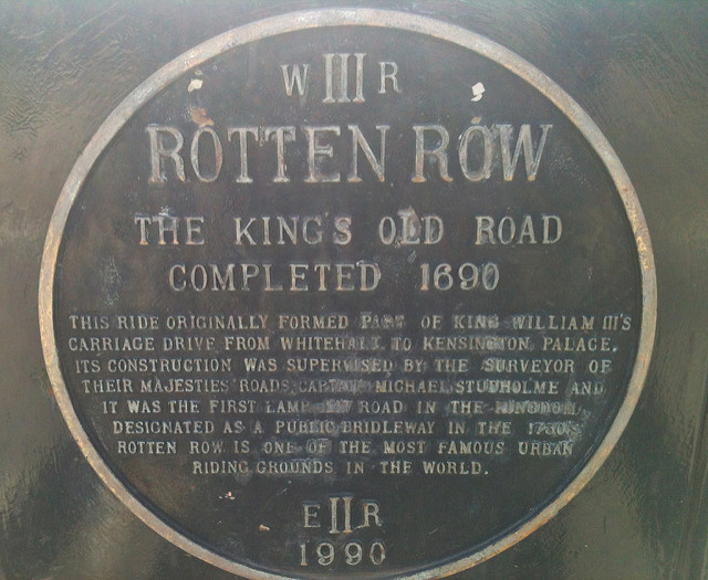 William III and Rotten Row blue plaque - WR III  Rotten Row  The King's Old Road completed 1690.  This ride originally formed part of King William III's carriage drive from Whitehall to Kensington Palace. Its construction was supervised by the surveyor of their Majesties roads Captain Michael Studholme and it was the first lamp-lit road in the Kingdom. Designated as a public bridleway in the 1730's, Rotten Row is one of the most famous urban riding grounds in the world.  ER II  1990
