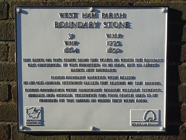 White plaque № 11180 - West Ham Parish Boundary Stone. 31 W.H.P. WHP 1775 1864 1850.  The dates on this stone show the years in which the boundary was confirmed. It was numbered 31 in 1864, but no longer marks any boundary. Parish boundary markers were beaten in an annual ceremony called The Beating of the Bounds. Parish boundaries were significant because welfare payments, burials and medical treatment for poor people used to be provided by the parish in which they were born.